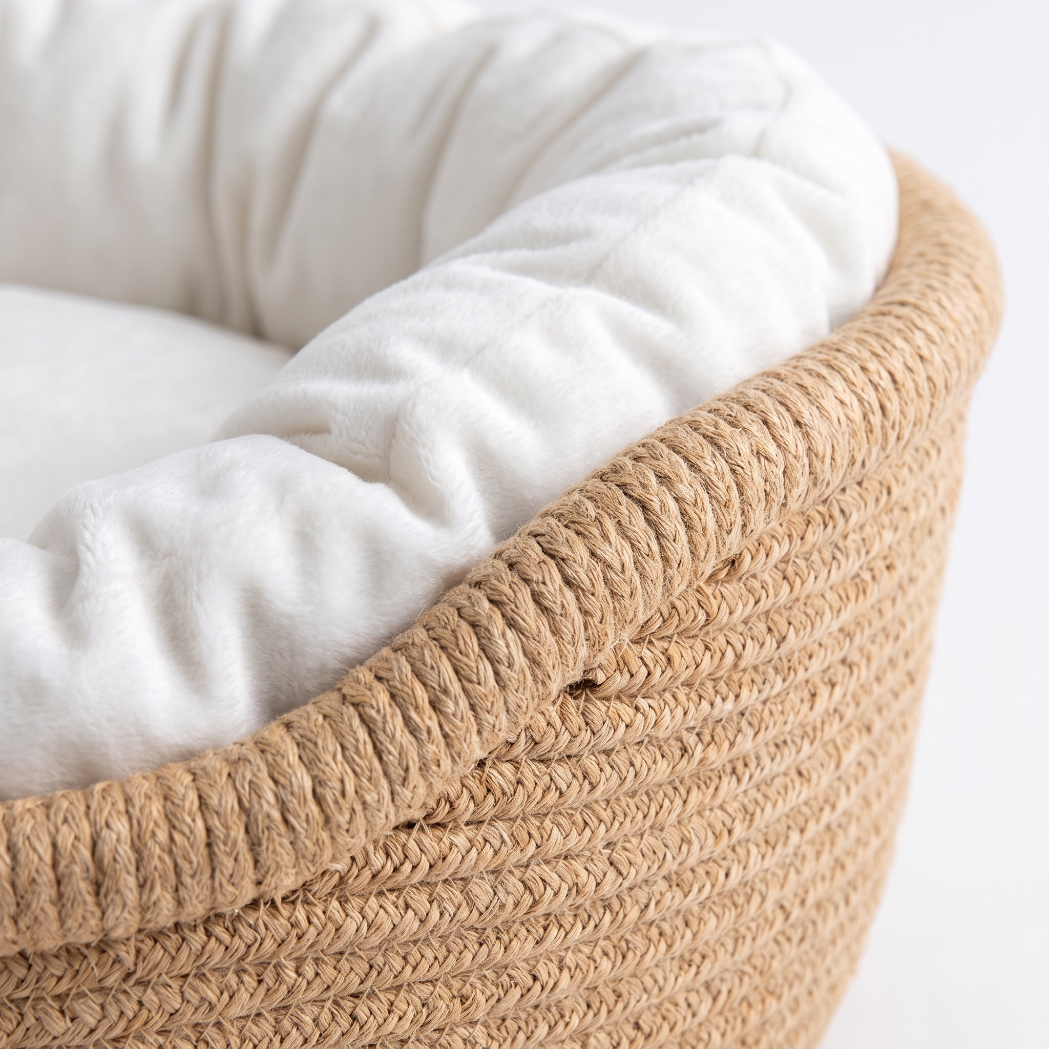 Macro detail of hand-woven rope and soft white cushion draping over the rim