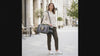 Woman carrying the Astra bubble-window cat carrier crossbody, cat looking out the window