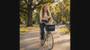 Woman riding a bike with her cat in the Scout front basket carrier