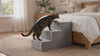 Cat climbing the Tier grey foam cat stairs up to a bed